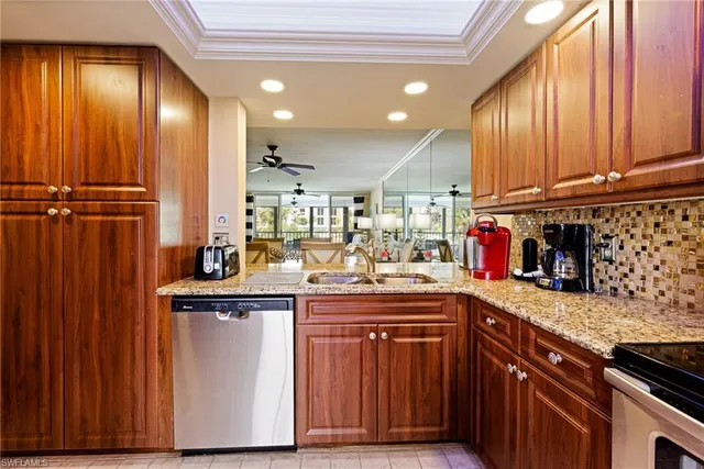 a kitchen with stainless steel appliances granite countertop a sink a stove cabinets and wooden floor