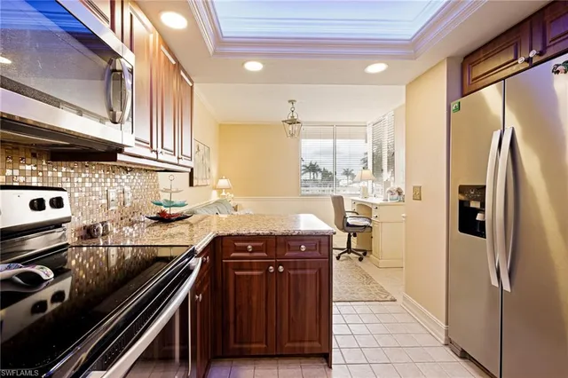 a kitchen with stainless steel appliances granite countertop a stove a sink and a refrigerator