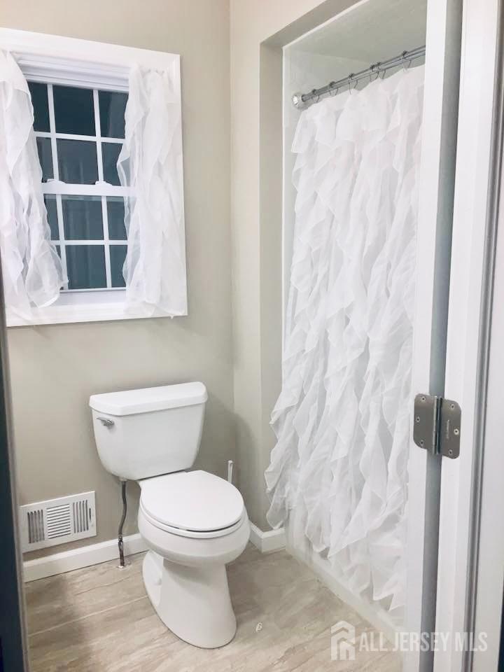 18 Timber Road East Brunswick, NJ 08816 - Photo 19 of 38 a white toilet sitting next to a shower curtain