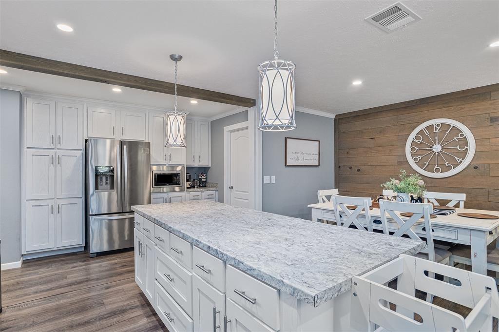 339 Cycle Plant Road Benton, LA 71006 - Photo 7 of 25 a kitchen with granite countertop a table chairs refrigerator and microwave
