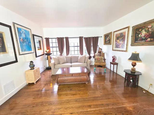 a bedroom with a bed wooden floor and windows