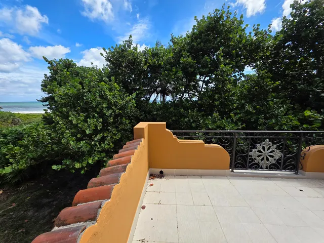 a view of roof deck with chairs and wooden fence