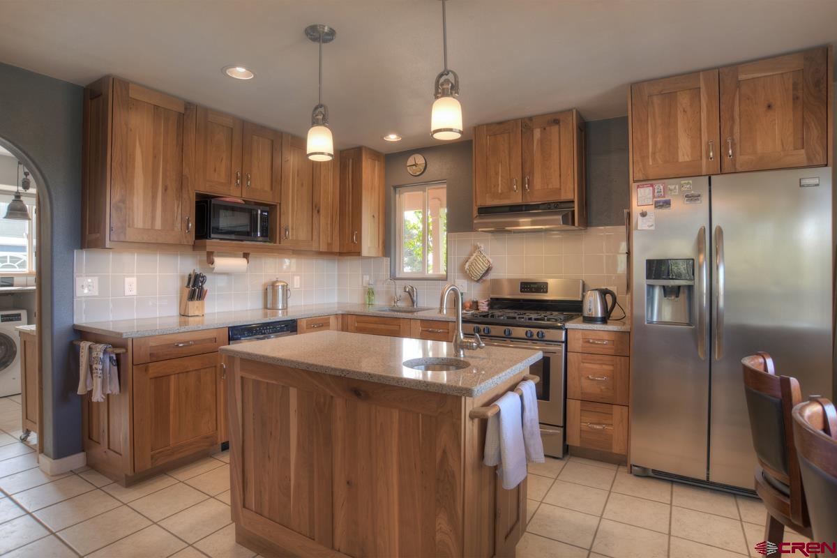 177 Sundance Hills Road Durango, CO 81303 - Photo 12 of 35 a kitchen with stainless steel appliances granite countertop a sink a stove a refrigerator and a microwave