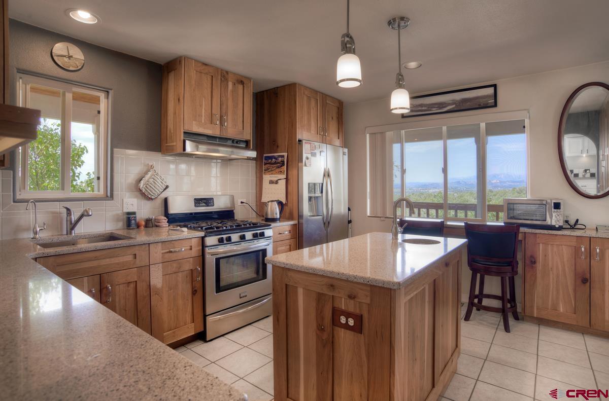 177 Sundance Hills Road Durango, CO 81303 - Photo 13 of 35 a kitchen with kitchen island granite countertop a sink stove and refrigerator