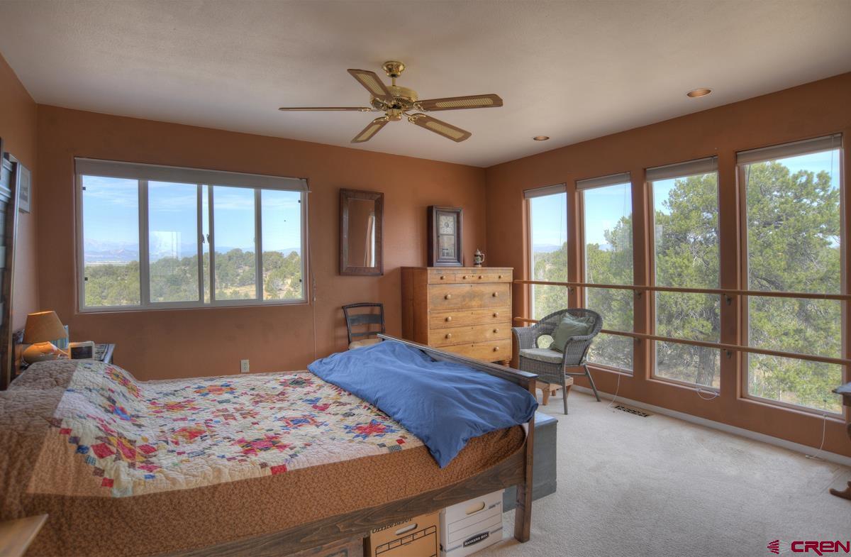 177 Sundance Hills Road Durango, CO 81303 - Photo 16 of 35 a bedroom with a large bed and large windows