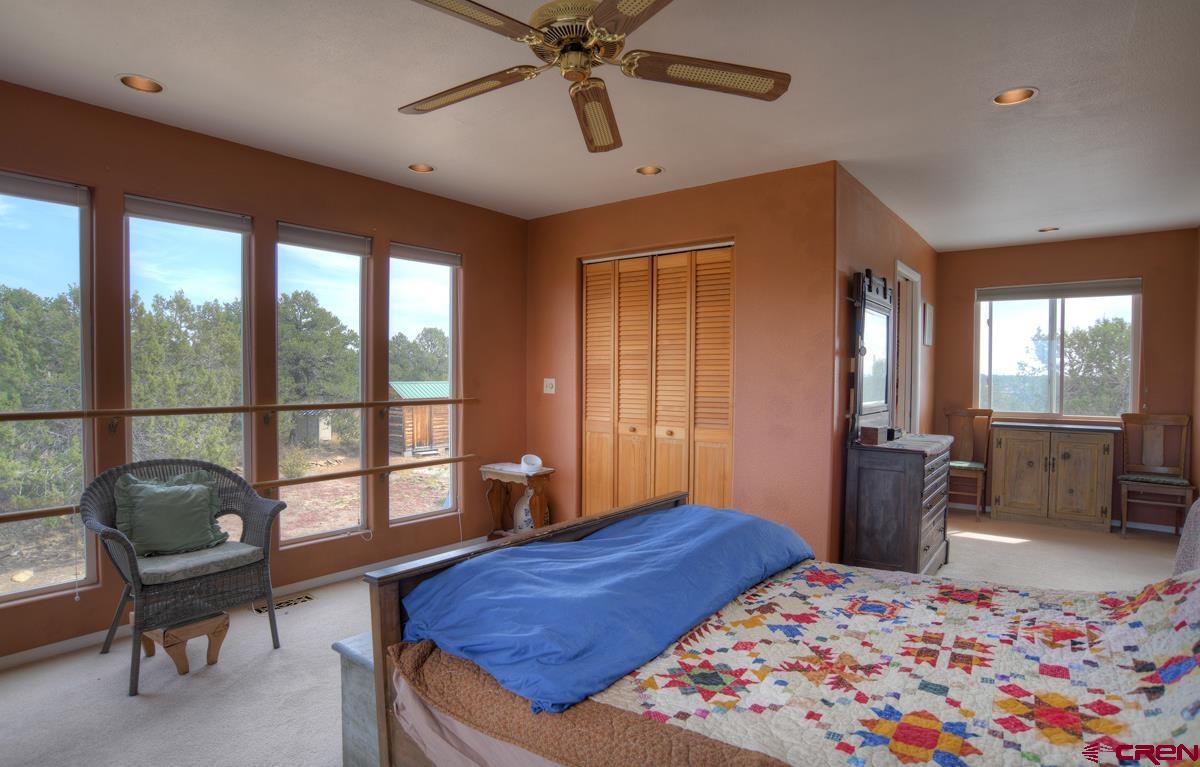 177 Sundance Hills Road Durango, CO 81303 - Photo 19 of 35 a bedroom with a bed and a chandelier