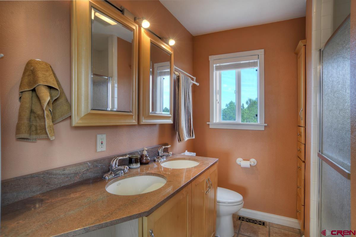 177 Sundance Hills Road Durango, CO 81303 - Photo 20 of 35 a bathroom with a granite countertop sink and a mirror