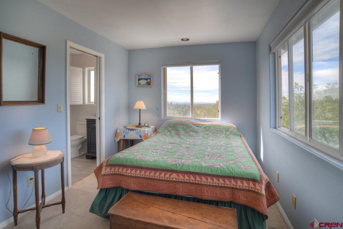 177 Sundance Hills Road Durango, CO 81303 - Photo 22 of 35 a bedroom with a bed and windows