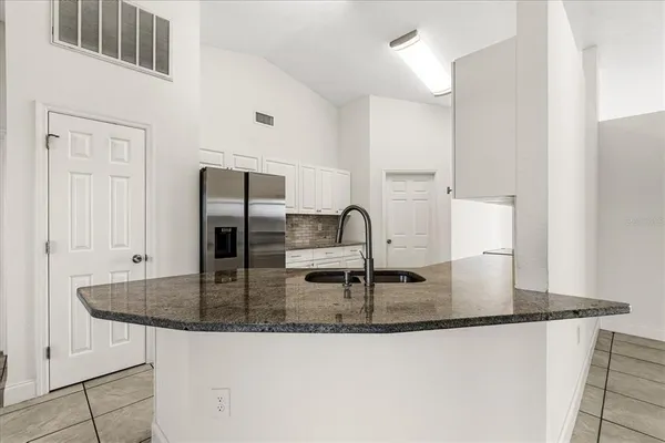 a kitchen with kitchen island a counter top space cabinets and stainless steel appliances