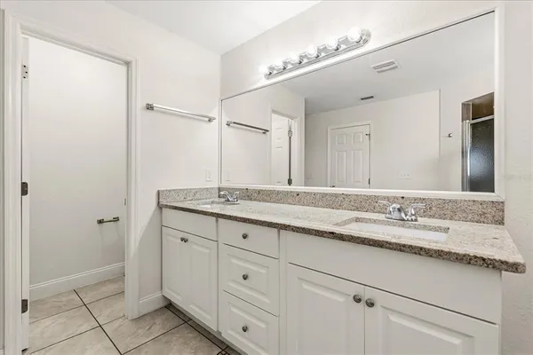 a bathroom with a granite countertop sink and a mirror