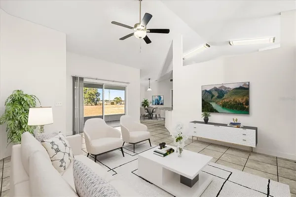 a living room with furniture a flat screen tv and a floor to ceiling window