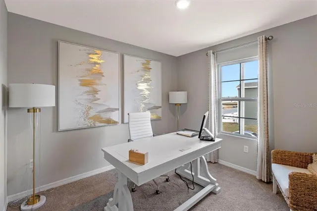 a view of a workspace with furniture and a window