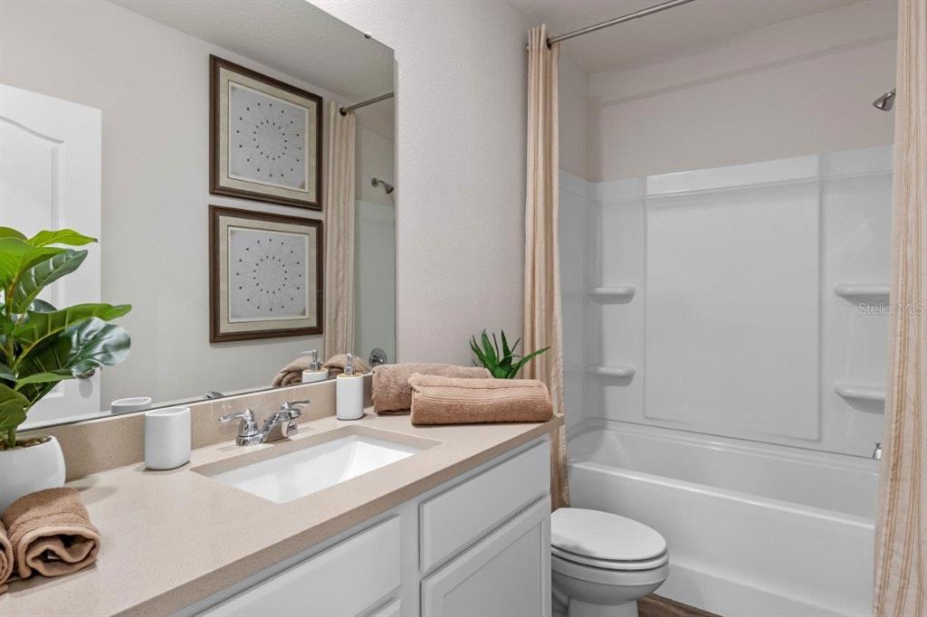 2729 Gladiola Road Winter Haven, FL 33884 - Photo 19 of 25 a bathroom with a granite countertop sink a toilet and shower