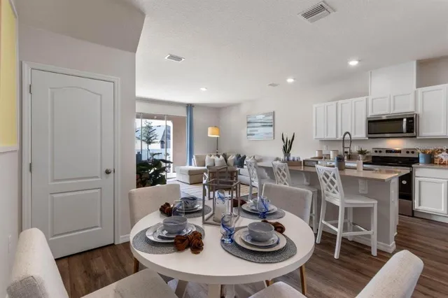 a living room with furniture a flat screen tv and kitchen view