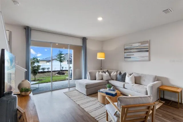 a living room with furniture and a floor to ceiling window