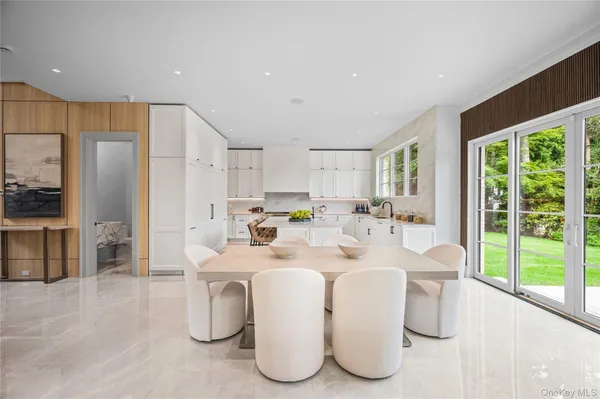 a dining room with furniture a large window and stainless steel appliances