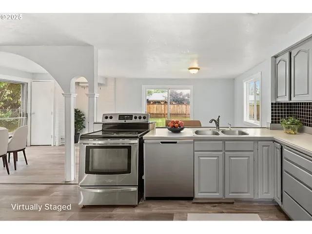 a kitchen with stainless steel appliances granite countertop a stove a sink and a refrigerator