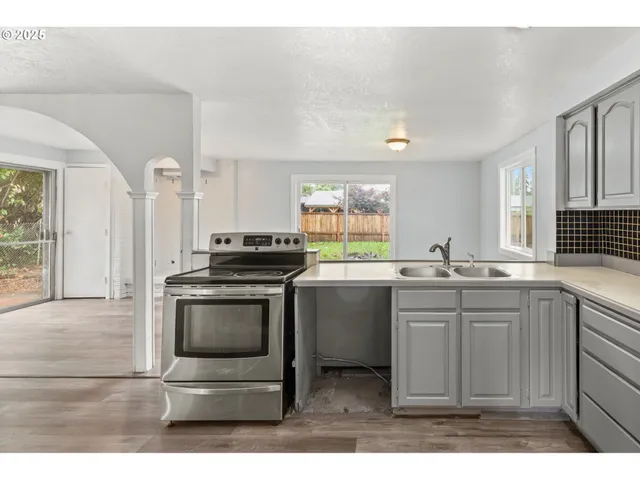 a kitchen with stainless steel appliances granite countertop a sink and a stove