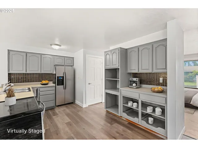 a kitchen with kitchen island white cabinets and refrigerator