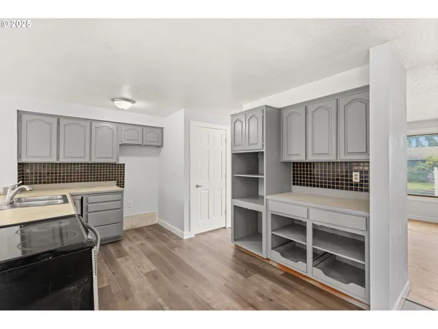 a kitchen with a refrigerator and a stove top oven