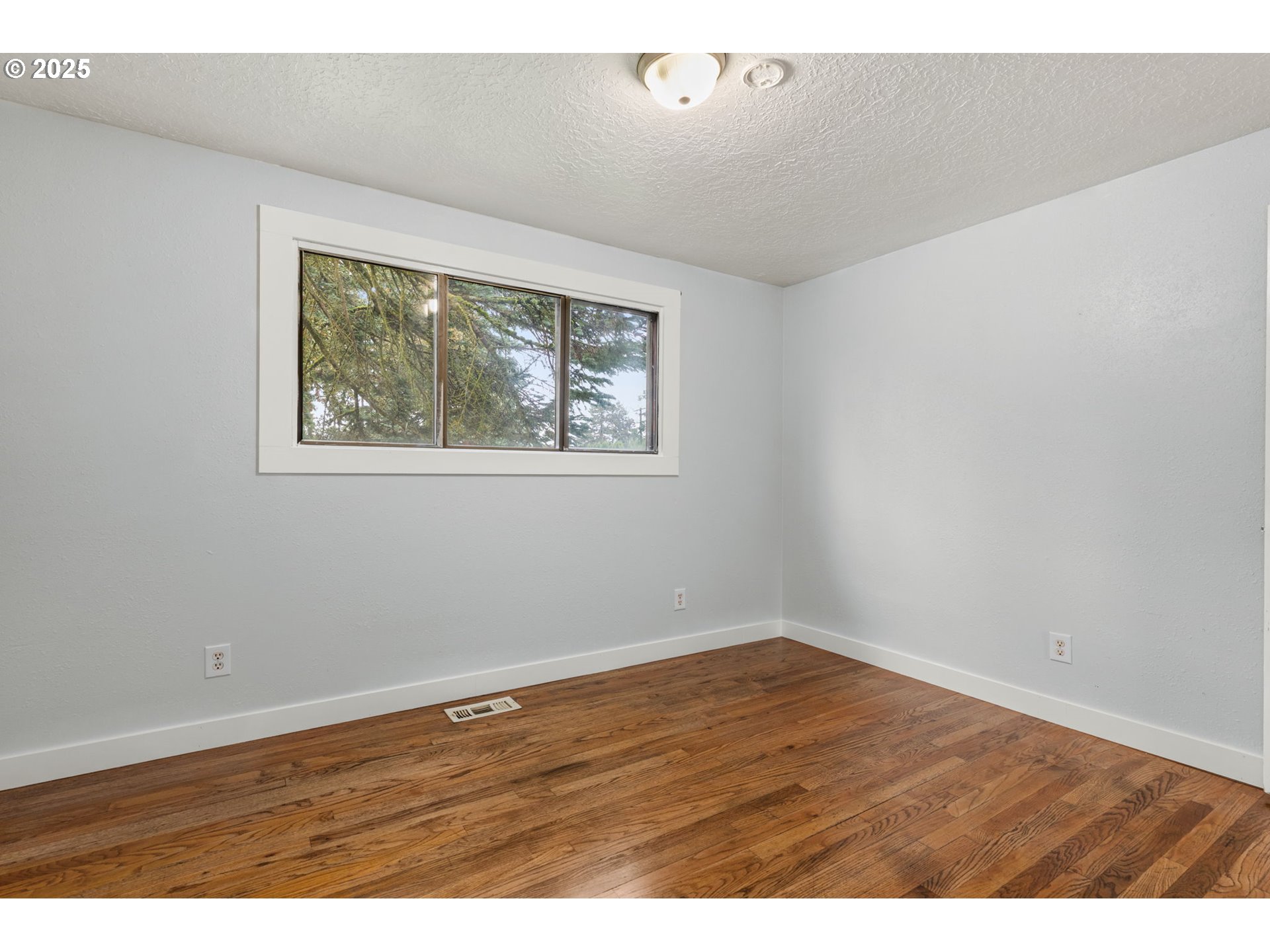1203 Northeast 190th Place Portland, OR 97230 - Photo 27 of 48 an empty room with wooden floor and windows