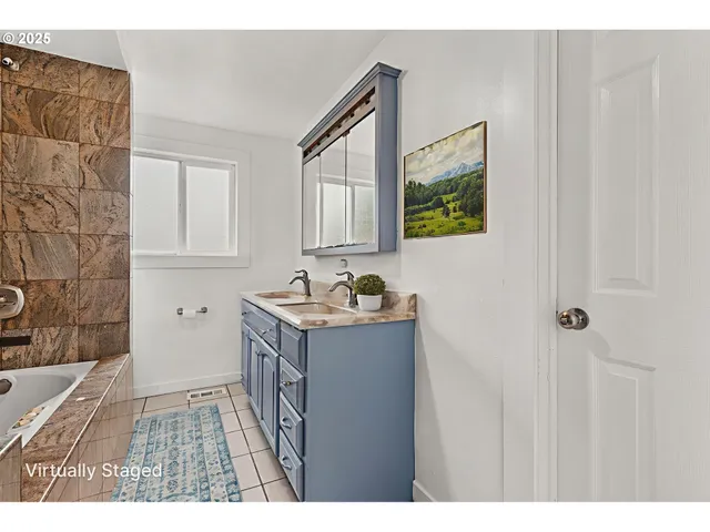 a bathroom with a granite countertop sink a mirror and a bathtub