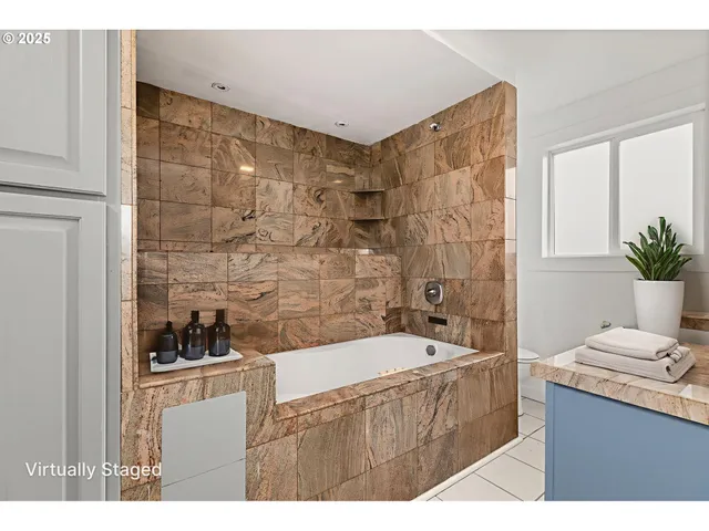 a bathroom with a tub a sink a mirror and a shower