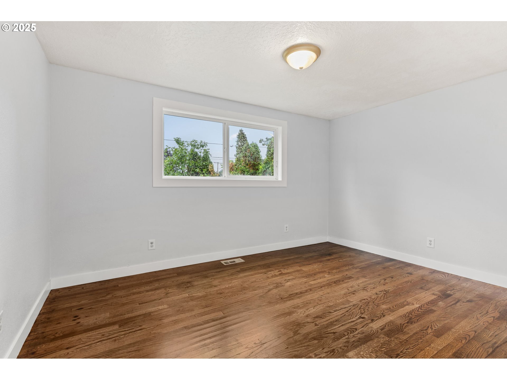 1203 Northeast 190th Place Portland, OR 97230 - Photo 34 of 48 an empty room with wooden floor and window