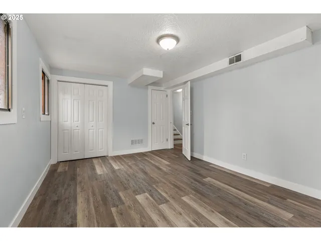a view of an empty room with wooden floor