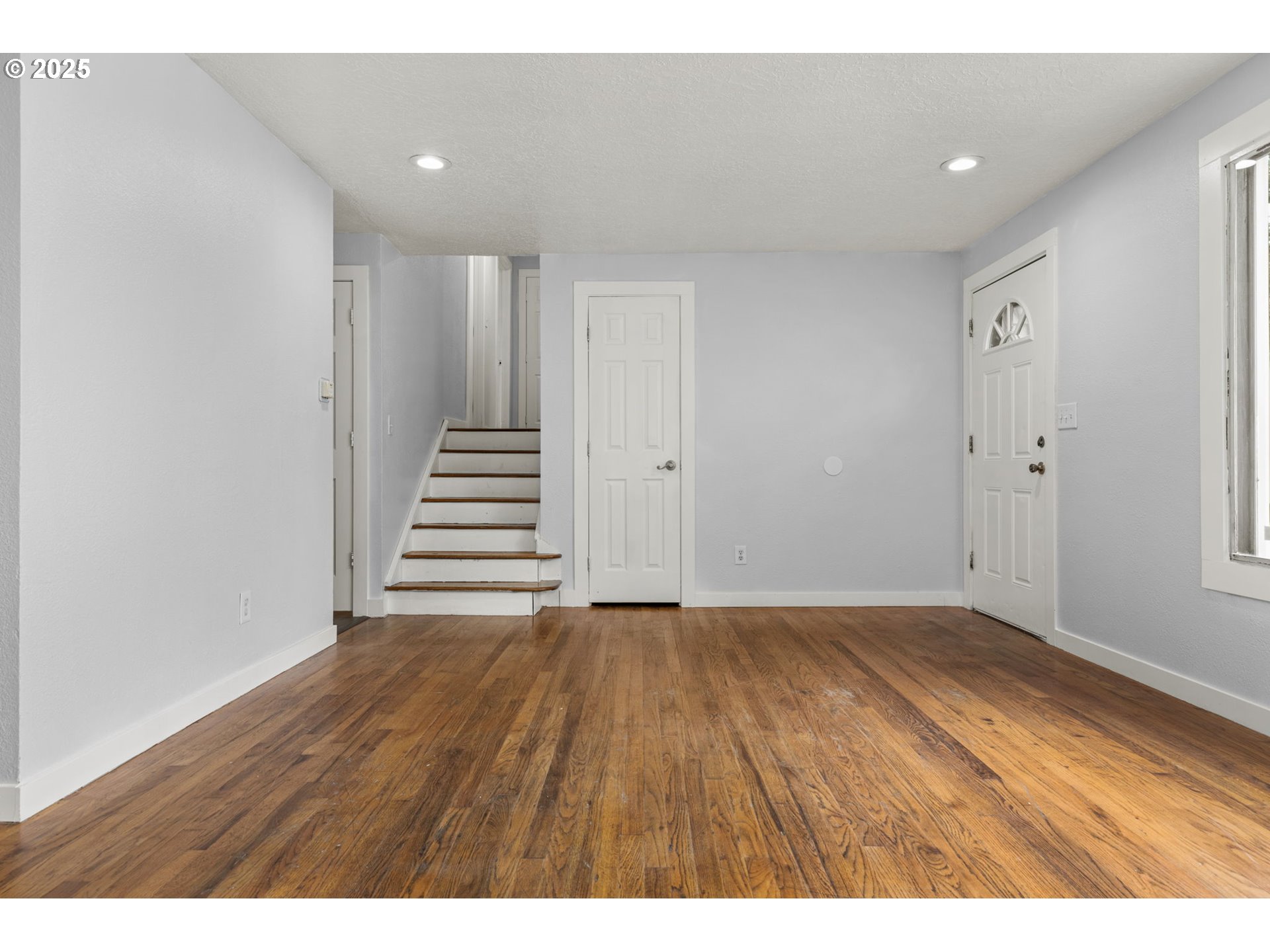 1203 Northeast 190th Place Portland, OR 97230 - Photo 8 of 48 a view of an empty room with wooden floor and stairs