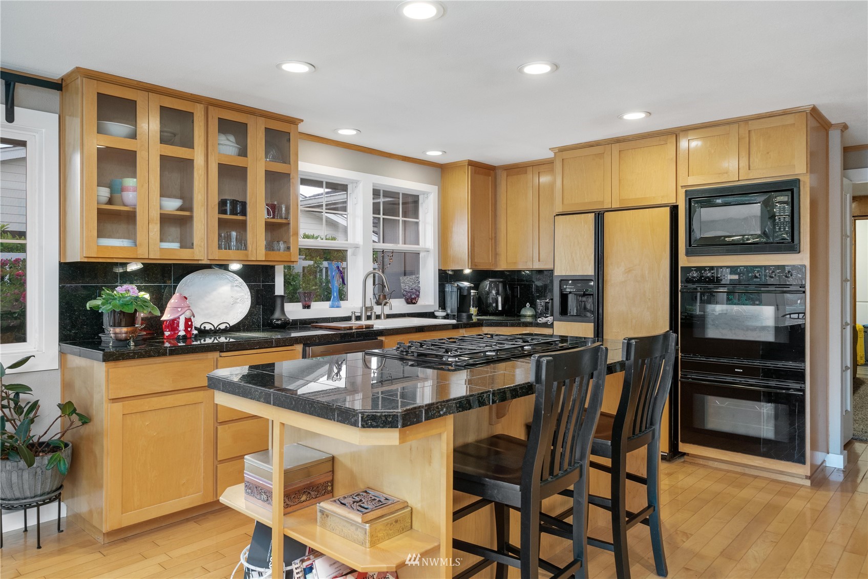 9215 Lake Steilacoom Point Road Southwest Lakewood, WA 98498 - Photo 17 of 36 a kitchen with a table chairs refrigerator and cabinets