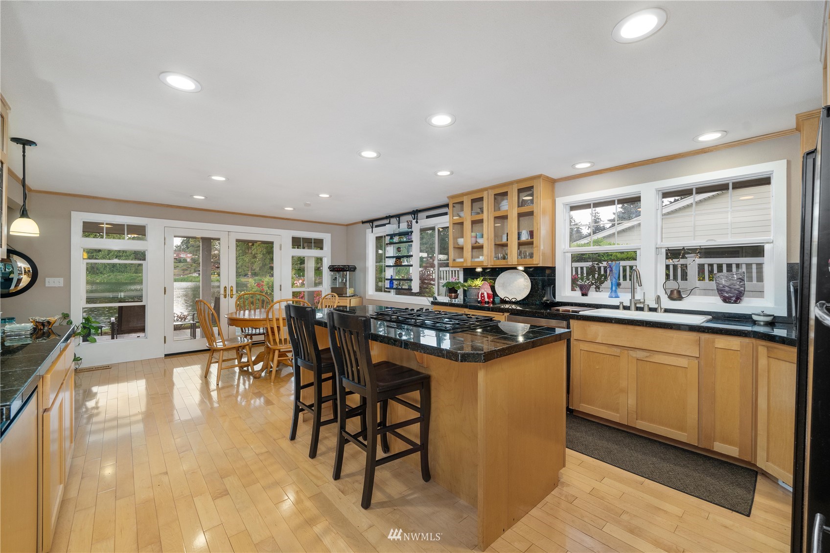 9215 Lake Steilacoom Point Road Southwest Lakewood, WA 98498 - Photo 18 of 36 a kitchen with stainless steel appliances granite countertop table chairs and a large window