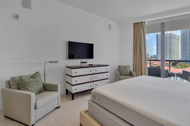 a bedroom with furniture and a flat screen tv