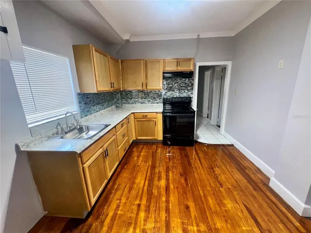 a kitchen with wooden floors and a sink