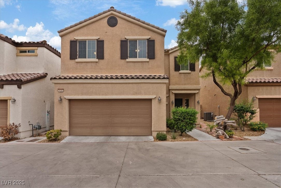Mediterranean / spanish house featuring driveway, stucco siding, a tiled roof, and a garage