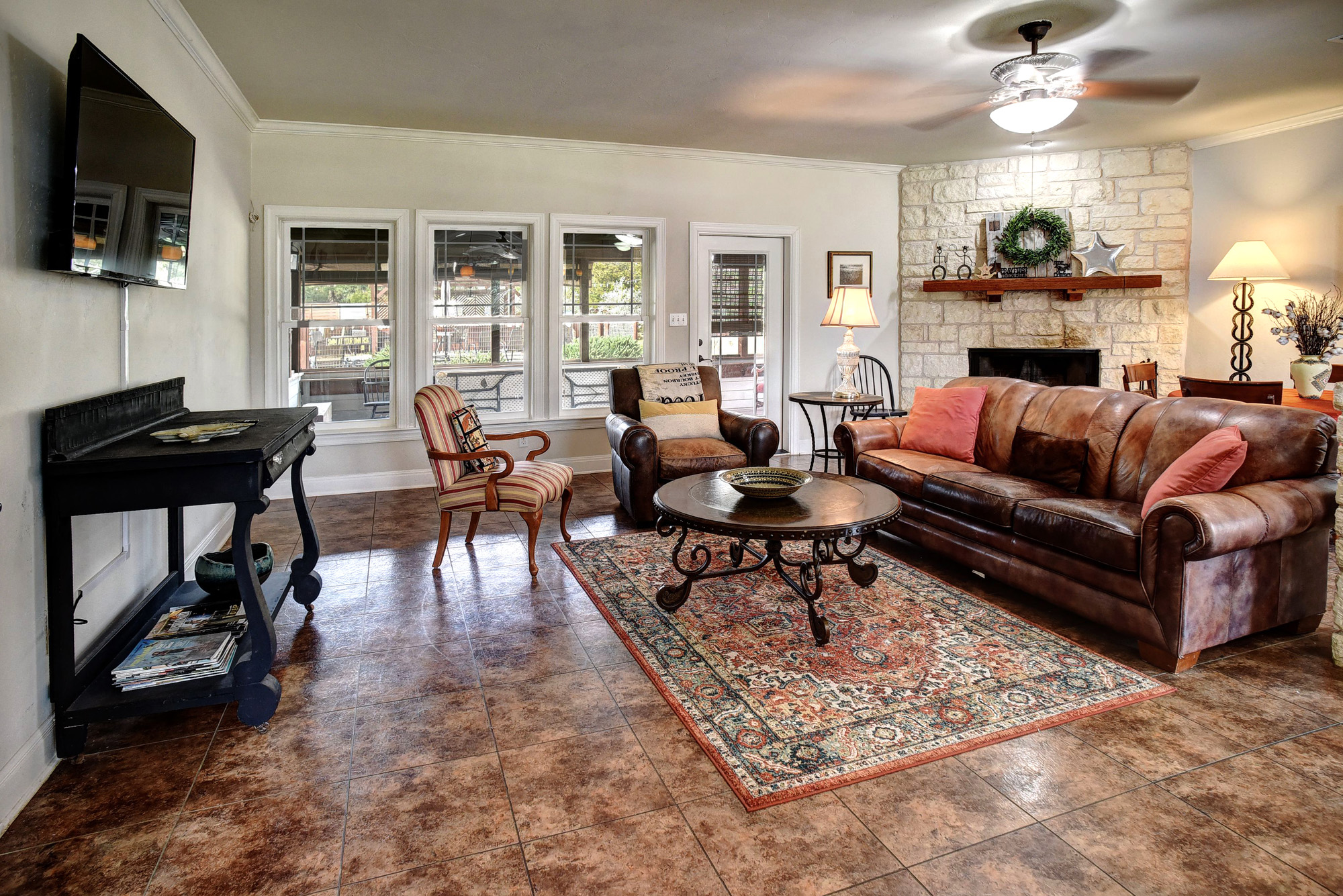 418 Vyvjala Road Smithville, TX 78957 - Photo 16 of 40 Living area with a stone fireplace, ornamental molding, and a ceiling fan