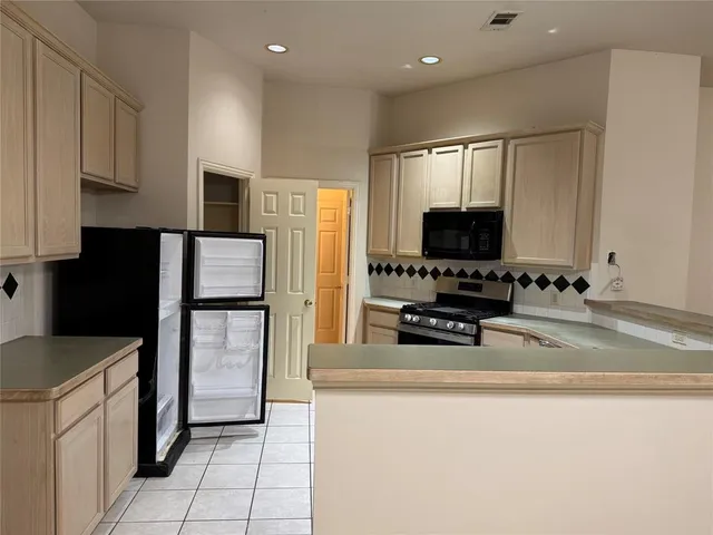 a kitchen with stainless steel appliances a refrigerator a stove a microwave and a sink