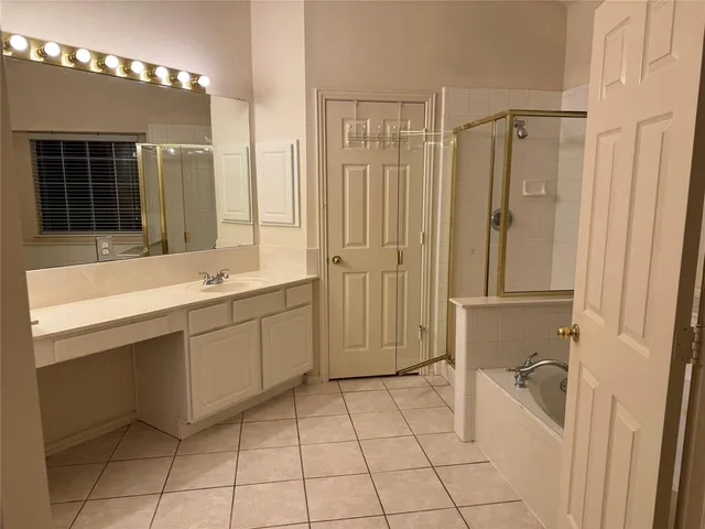 a spacious bathroom with a mirror a bathtub and a shower