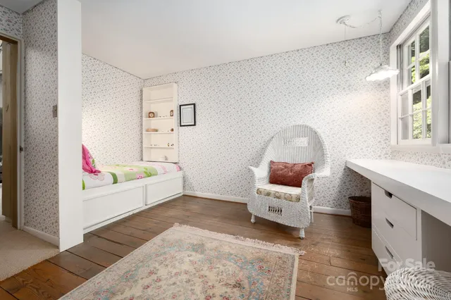 a large white bed sitting in a bedroom next to a window