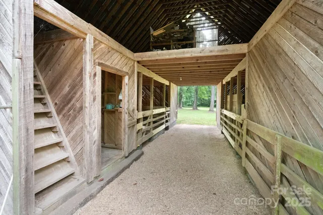 a view of a house with large trees and a forest