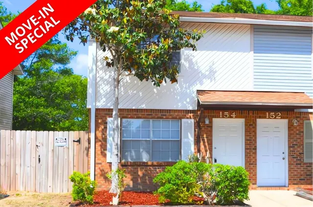 a view of brick house with potted plants