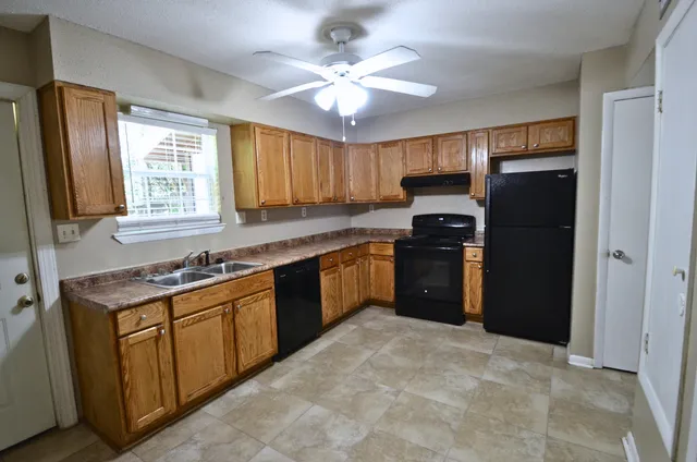 a kitchen with a refrigerator sink and cabinets
