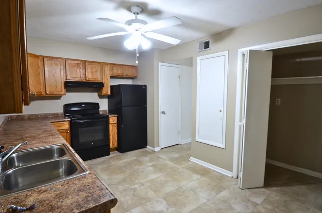a kitchen with a stove a refrigerator and a sink