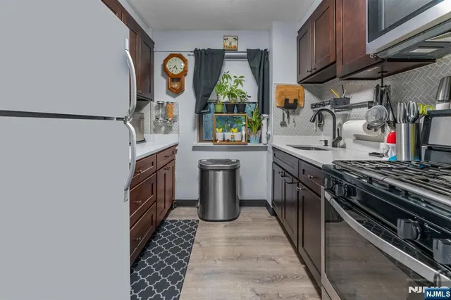 a kitchen with stainless steel appliances granite countertop a stove a sink and a refrigerator