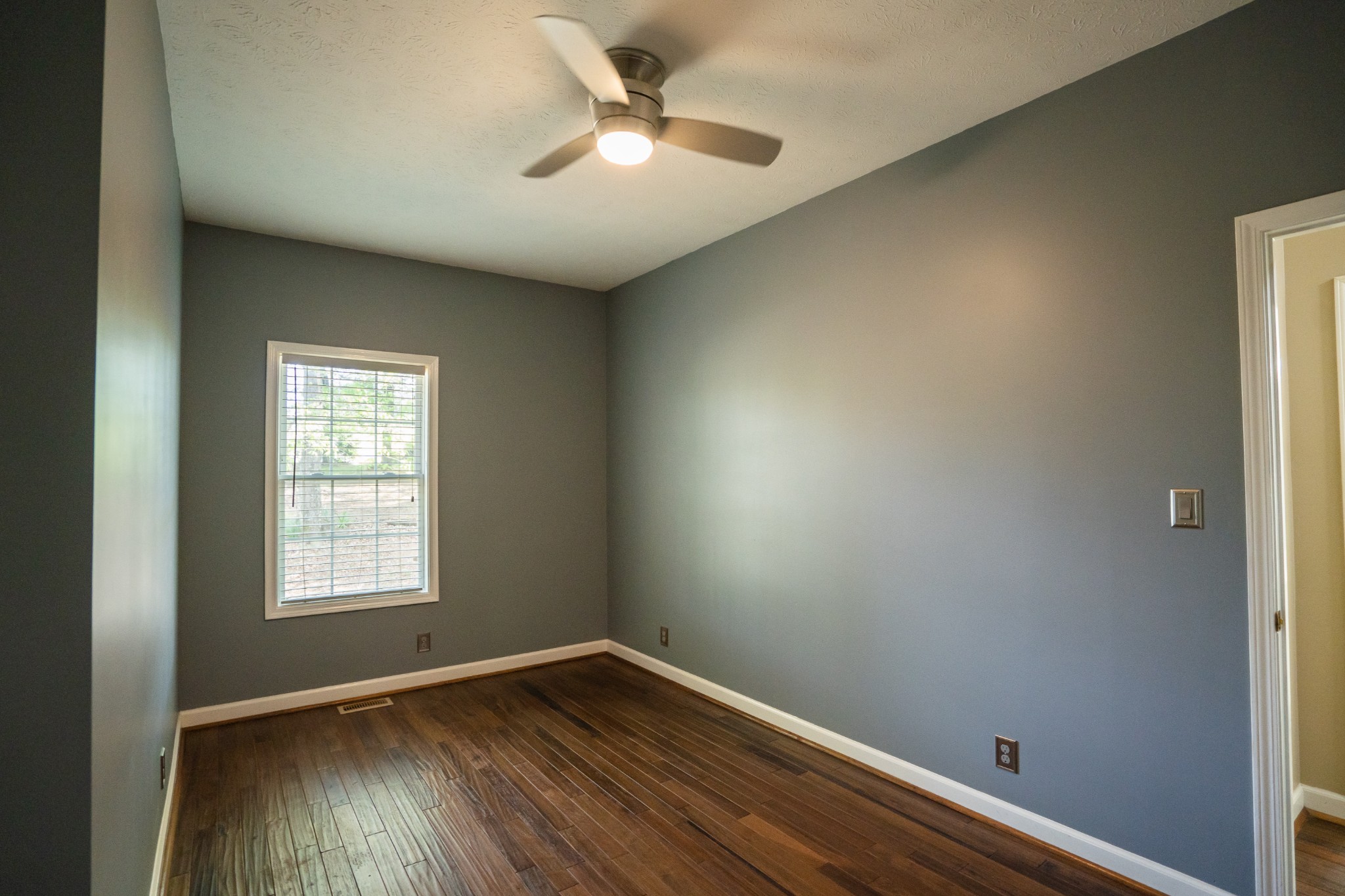 3077 Old Clarksville Sprgfld Road Adams, TN 37010 - Photo 12 of 33 an empty room with wooden floor chandelier fan and windows