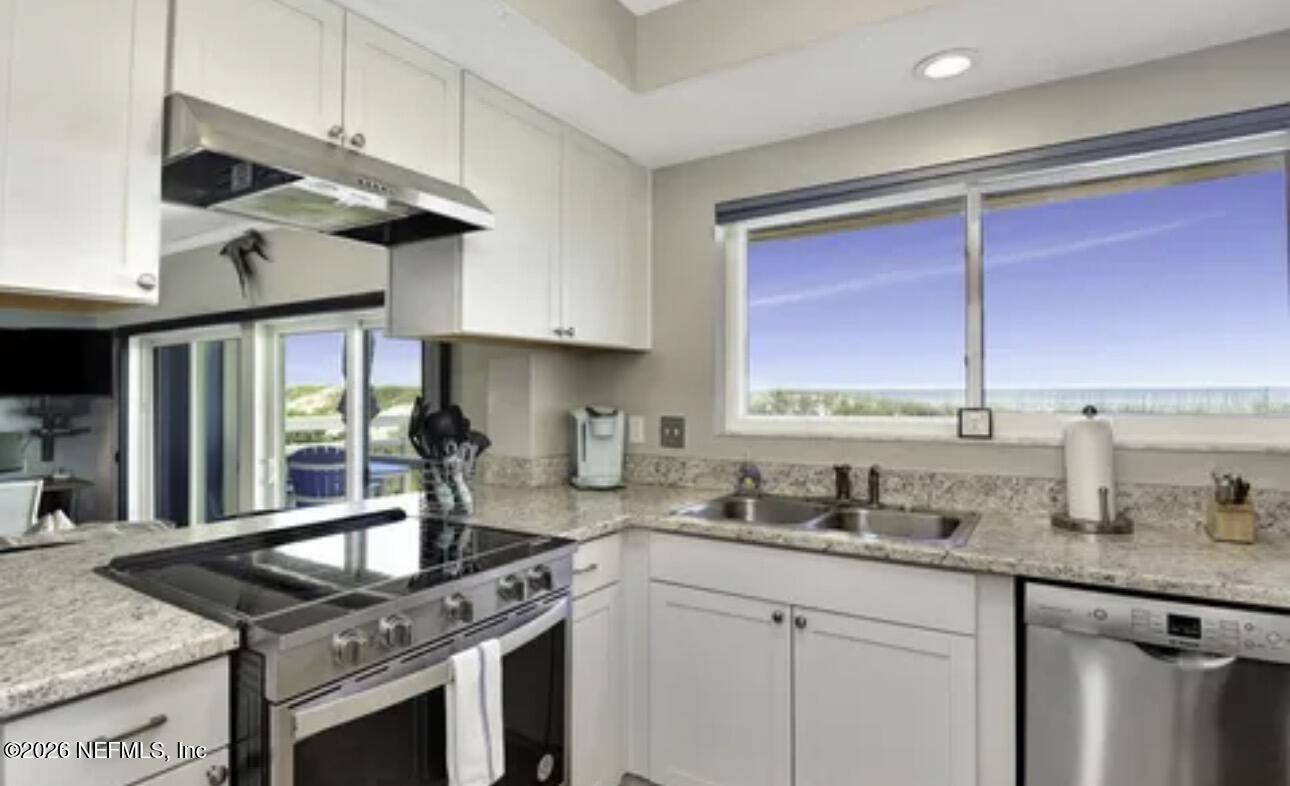 2 10th Street, Unit 2 St. Augustine Beach, FL 32080 - Photo 11 of 55 a kitchen with stainless steel appliances granite countertop a sink a stove and a wooden cabinets