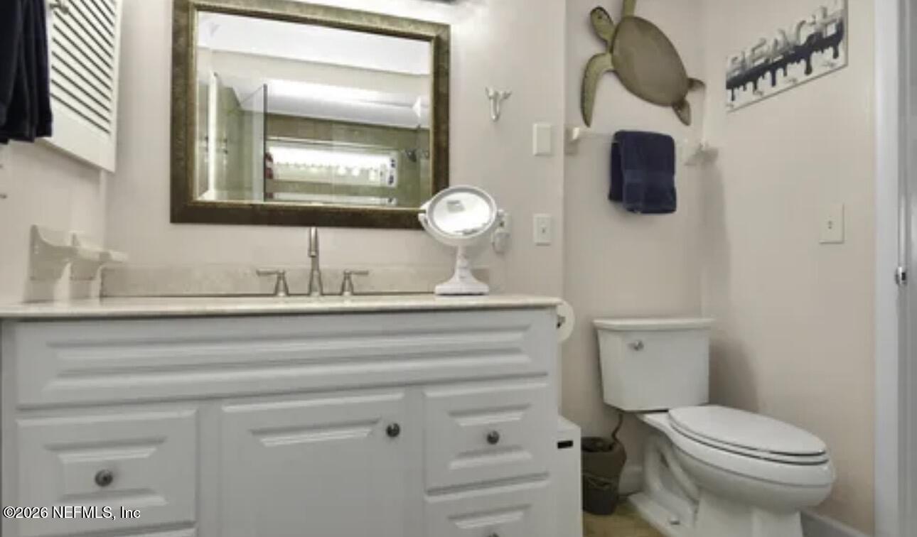 2 10th Street, Unit 2 St. Augustine Beach, FL 32080 - Photo 20 of 55 a bathroom with a toilet sink and mirror