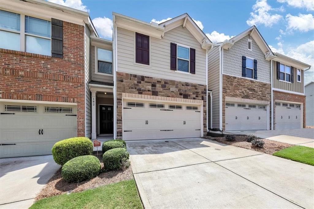182 Townview Drive Woodstock, GA 30189 - Photo 2 of 37 a view of a house with a small yard and a large tree