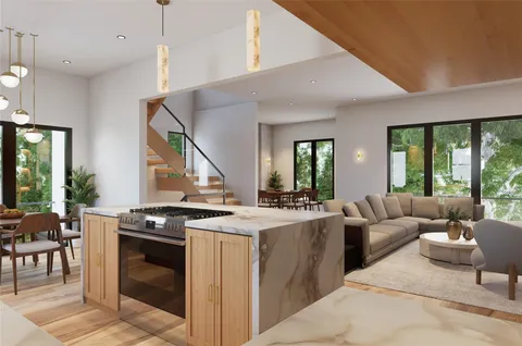 a open kitchen with stainless steel appliances granite countertop a stove and a living room