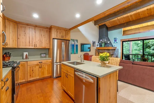 a kitchen with stainless steel appliances granite countertop a sink stove and refrigerator
